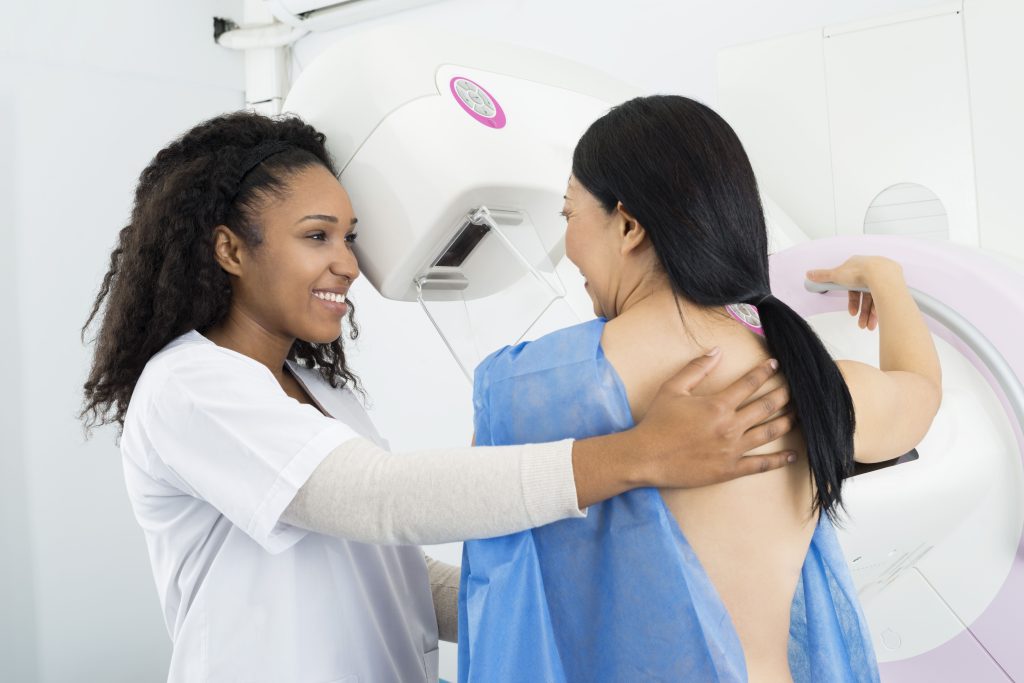 technologist assisting woman during mammogram